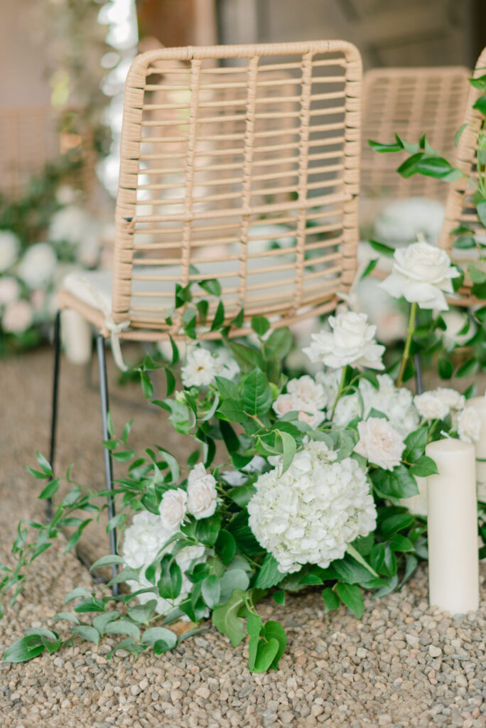 Intimate wedding ceremony with floral arches and rustic chairs